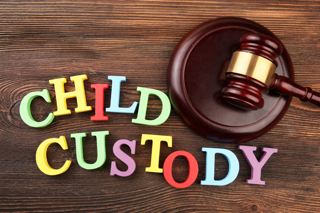 Colorful letters spelling CHILD CUSTODY with a wooden gavel beside it