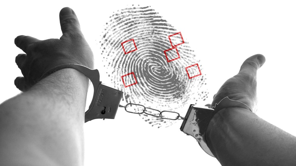 hand with handcuff and a finger print